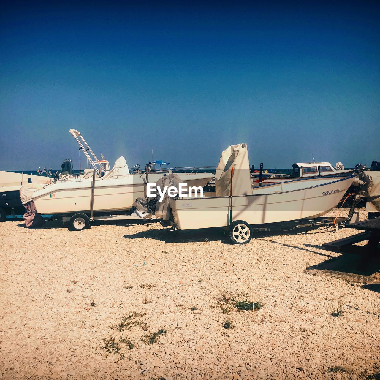 VIEW OF BOATS MOORED AT BEACH AGAINST CLEAR BLUE SKY