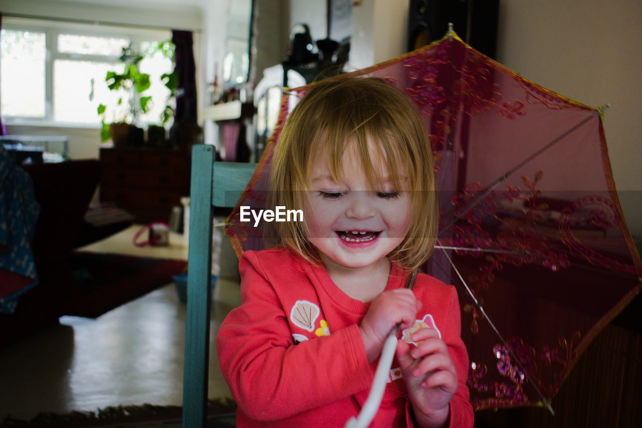 PORTRAIT OF A SMILING GIRL AT HOME