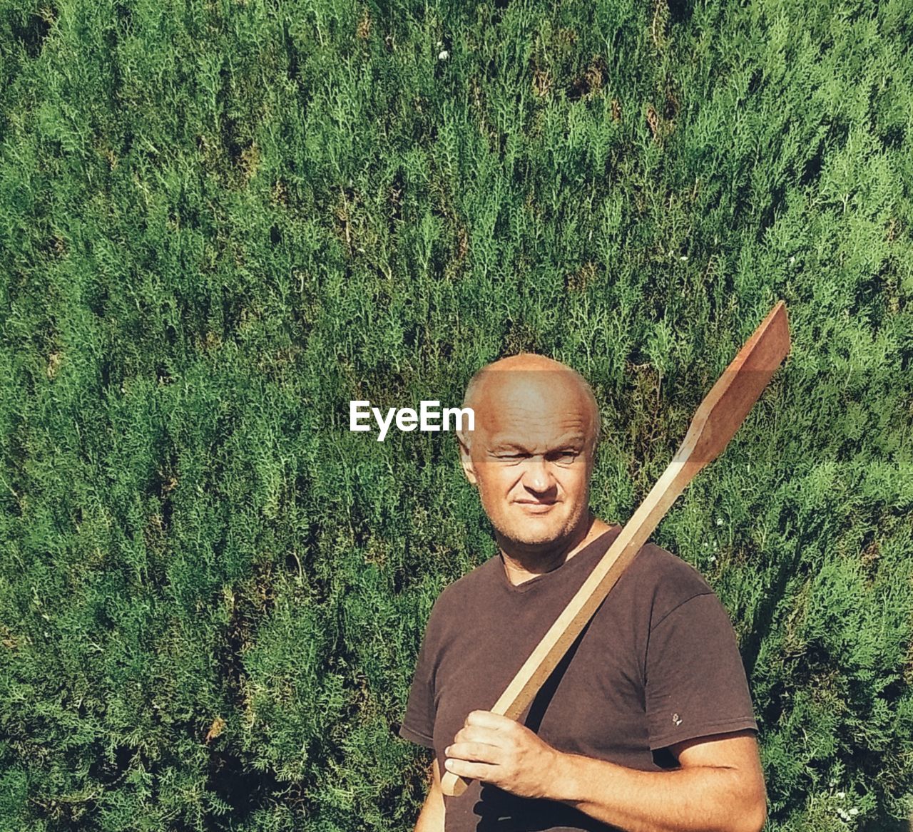 Man holding oar against plants