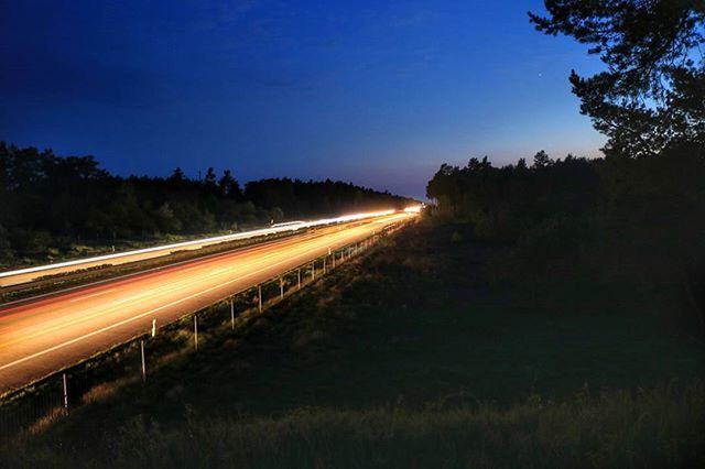 LIGHT TRAILS ON ROAD AT NIGHT