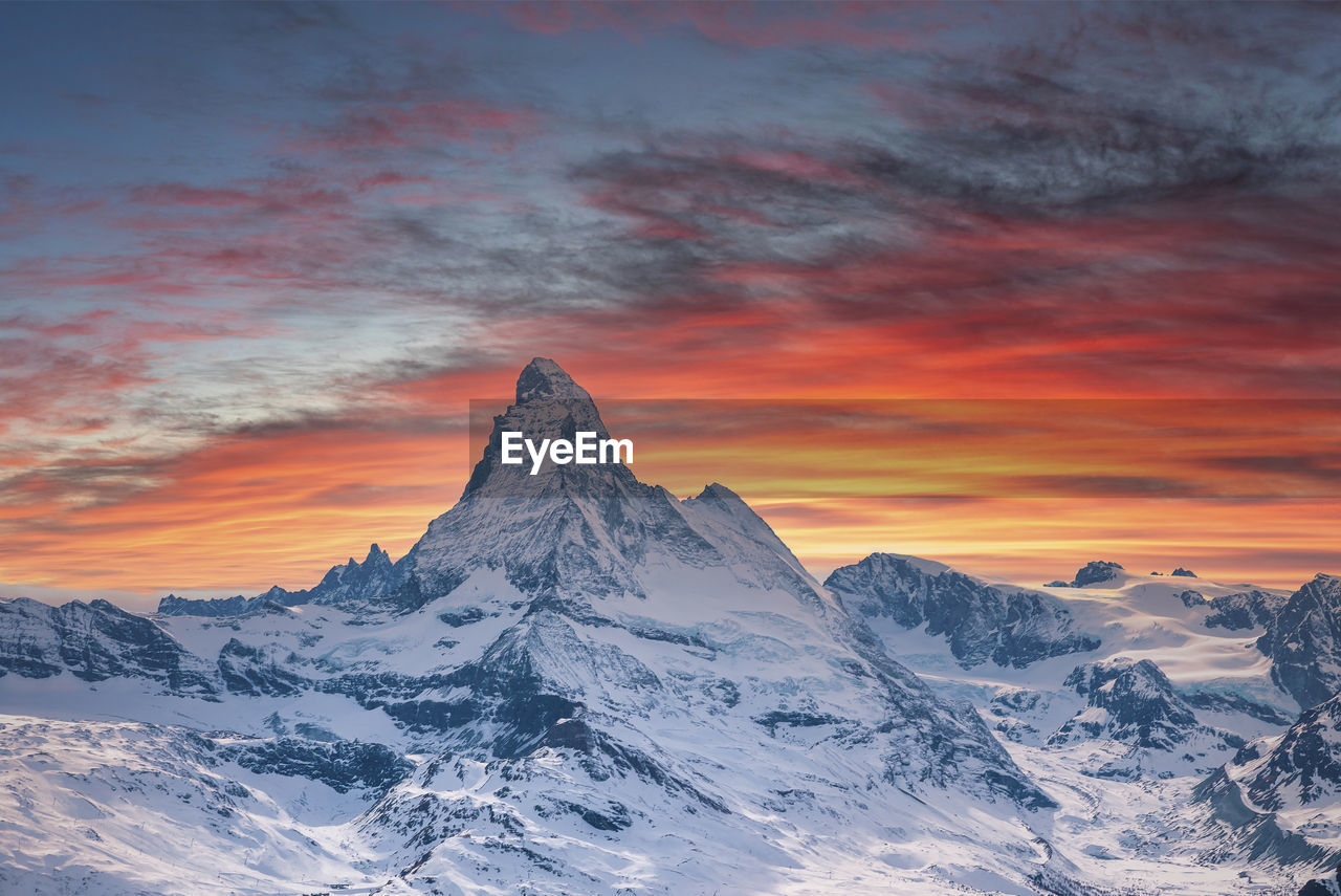 Idyllic matterhorn mountain in alps against cloudy sky during sunset