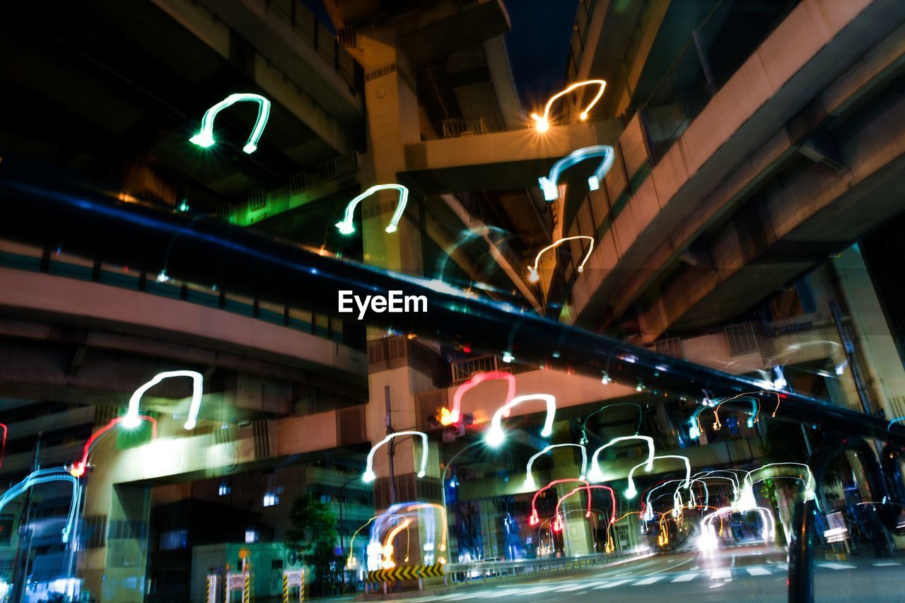 LOW ANGLE VIEW OF ILLUMINATED LIGHTS ON STREET AT NIGHT