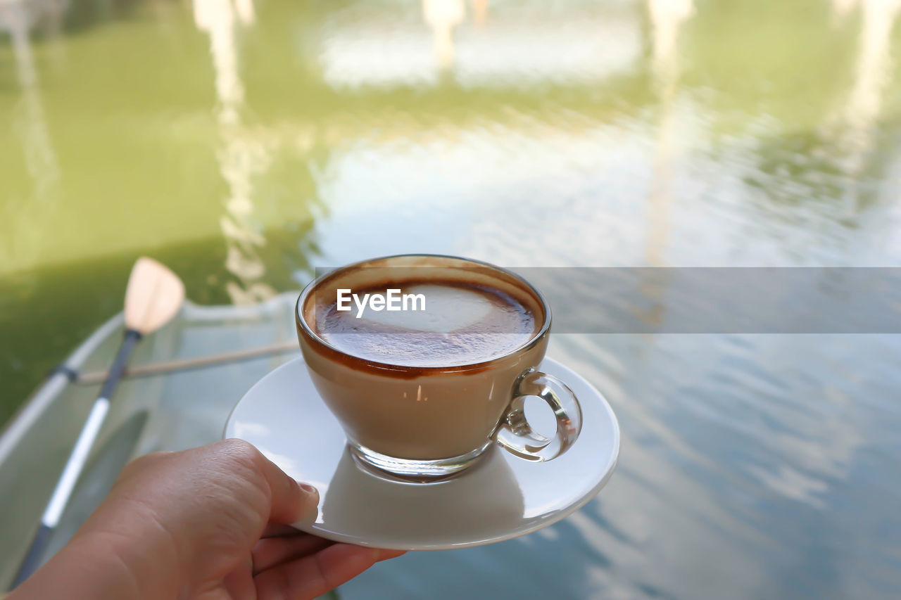 Close-up of hand holding coffee cup