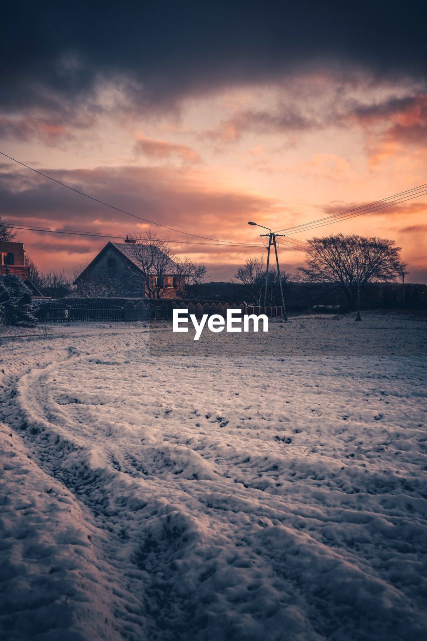 Scenic view of snow covered field against sky during sunset