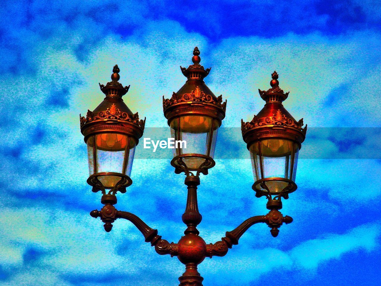 LOW ANGLE VIEW OF STREET LIGHTS AGAINST CLOUDY SKY