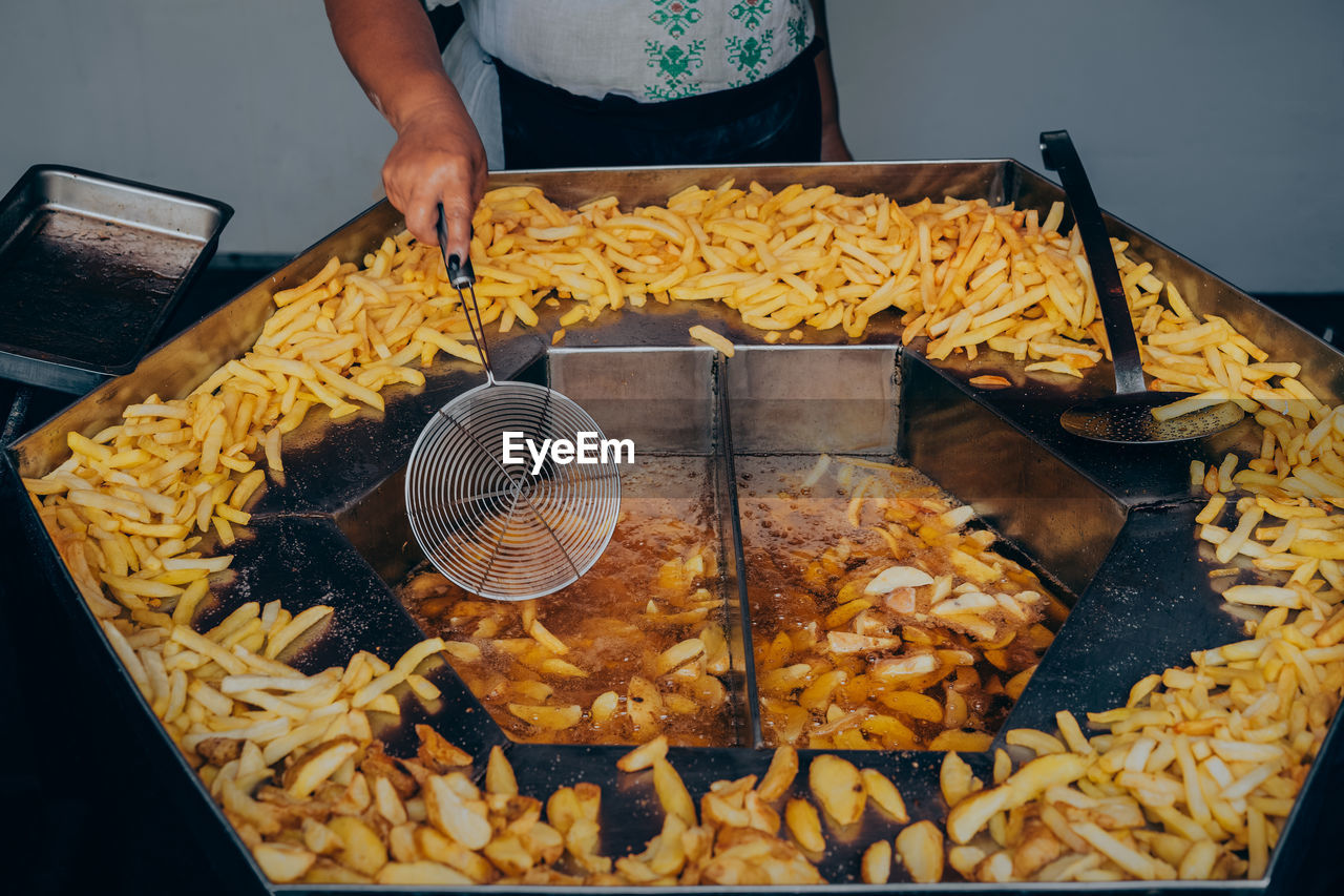 Midsection of man preparing french fries