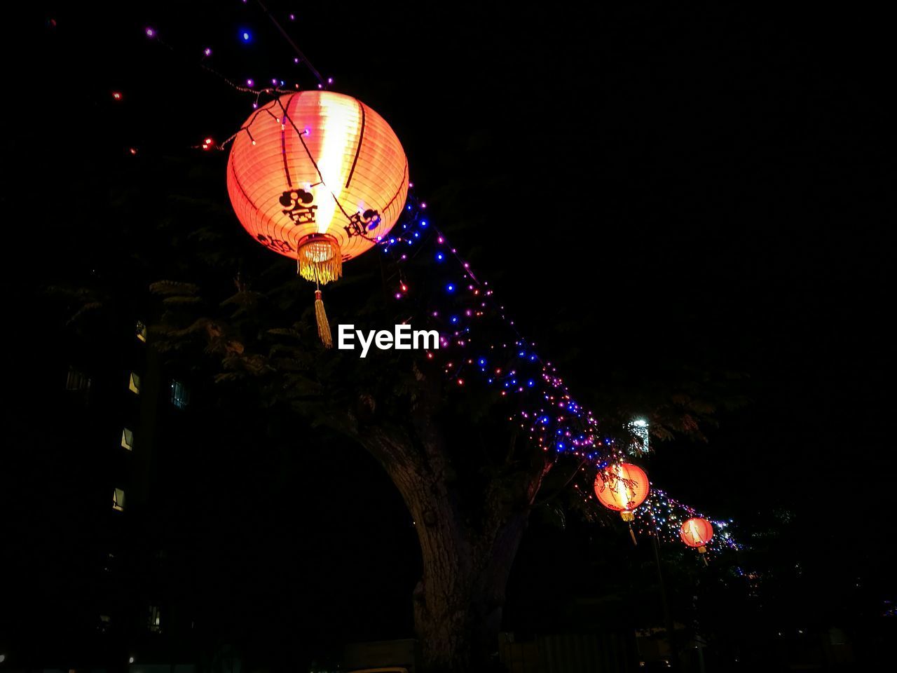 Low angle view of illuminated lanterns hanging at night