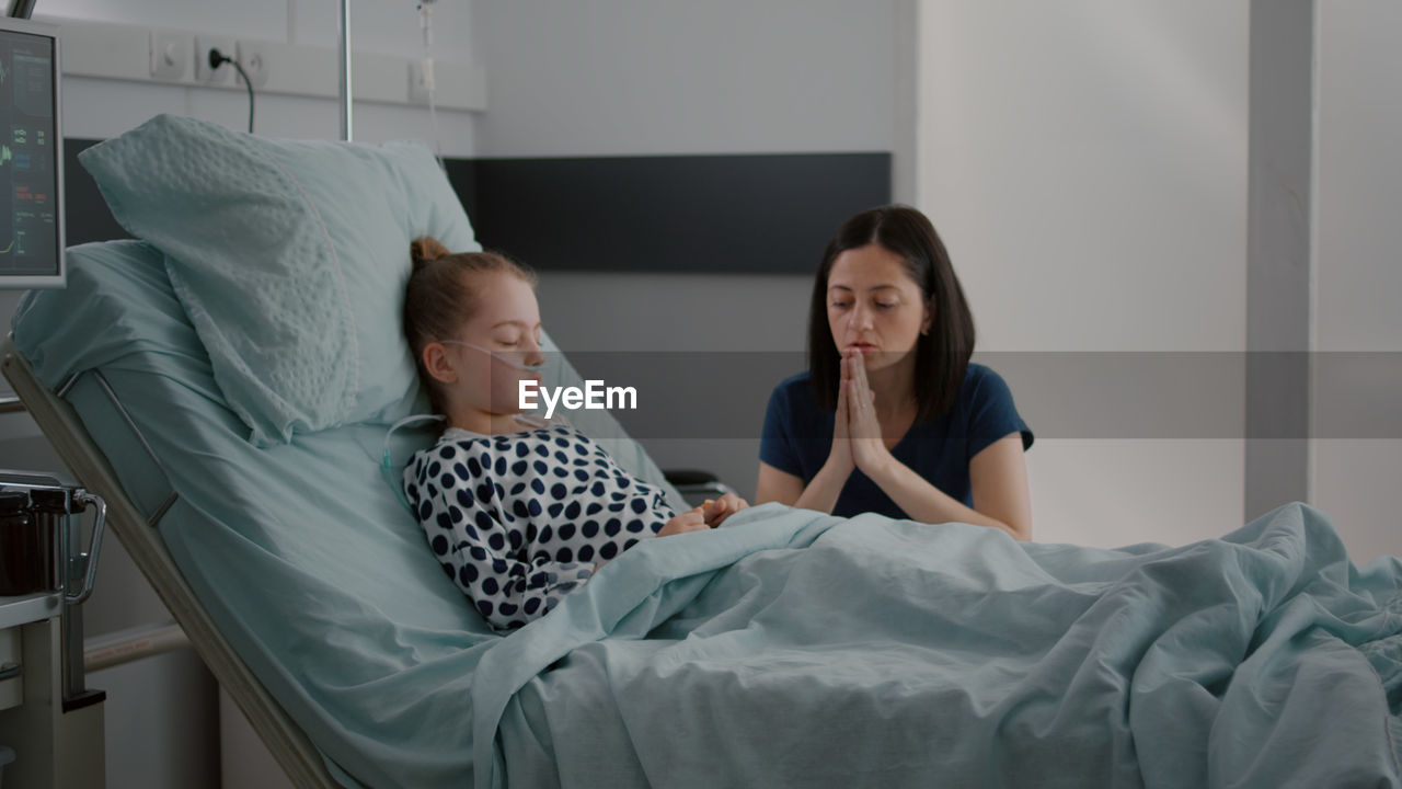 Portrait of young woman sleeping on bed at home