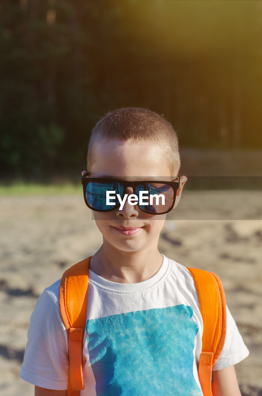 Summer portrait of a child wearing glasses with short hair outdoors