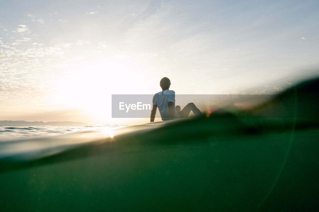 Concept: tranquility and relaxation. man sitting on paddle surf