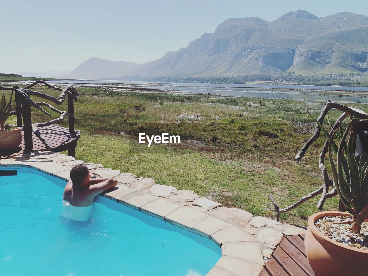 Swimming pool by mountains against sky