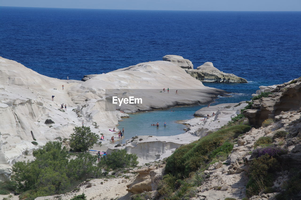 Scenic view of sea by cliff against sky