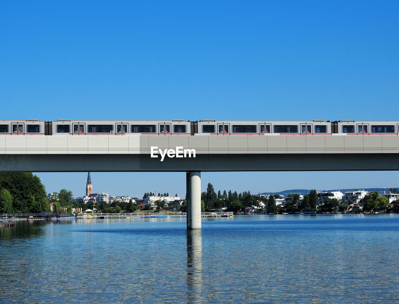 Bridge over sea against clear blue sky