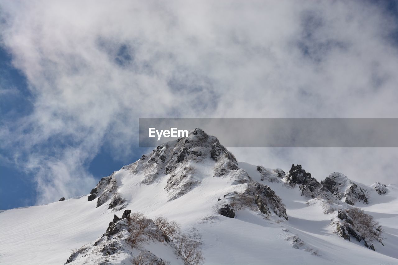 Low angle view of snowcapped mountain against sky