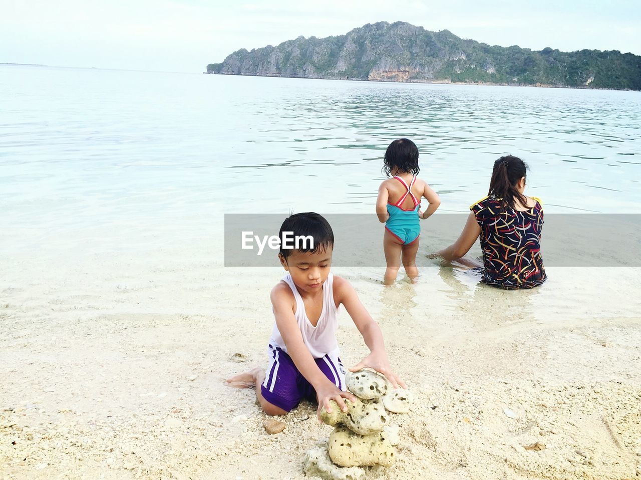 Family enjoying on sea shore at beach during sunny day