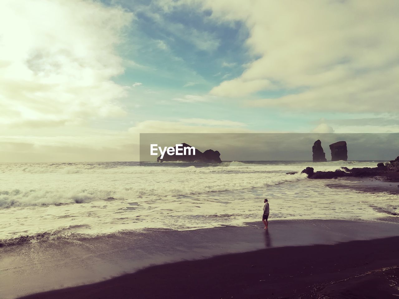 Man standing at beach against sky