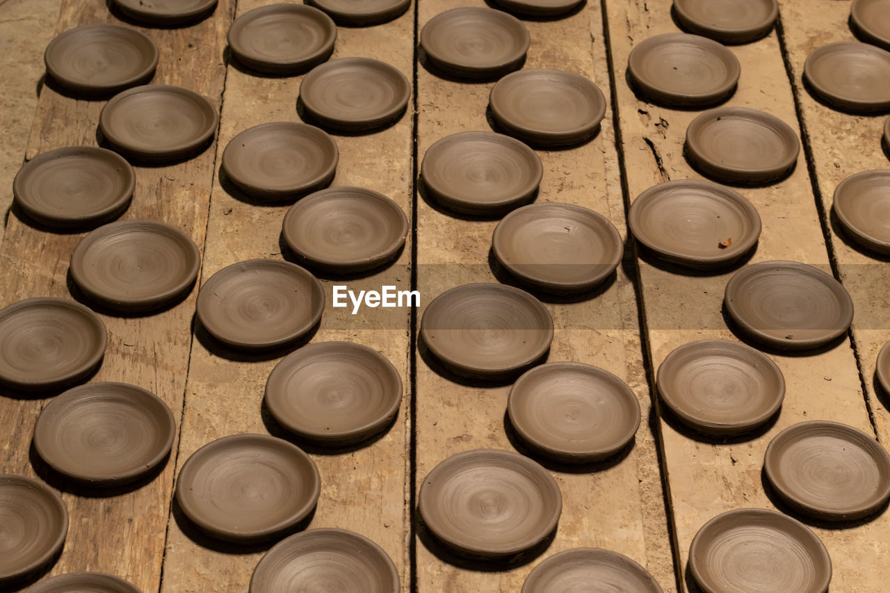 High angle view of clay plates on table