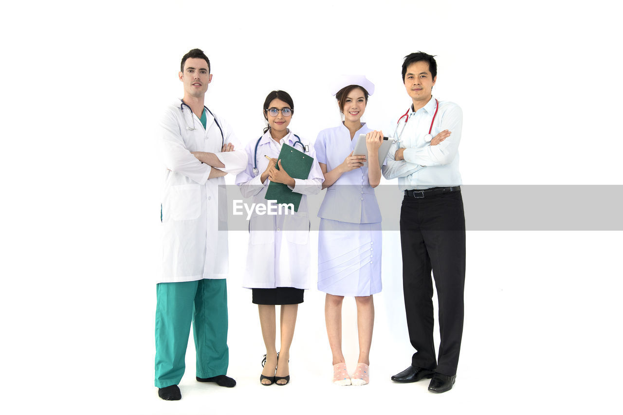 Doctors standing with nurse against white background