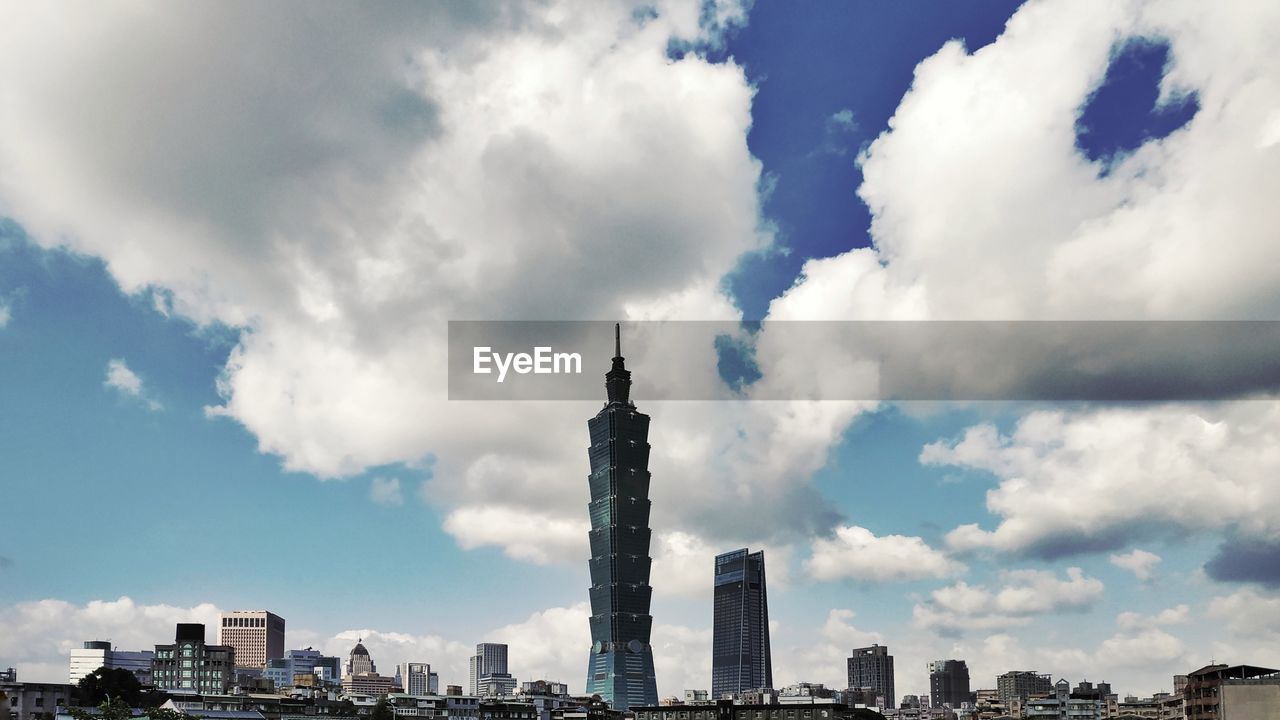 VIEW OF BUILDINGS AGAINST CLOUDY SKY