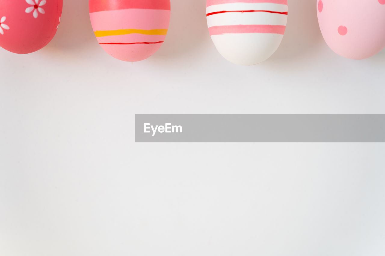 Close-up of multi colored easter eggs over white background