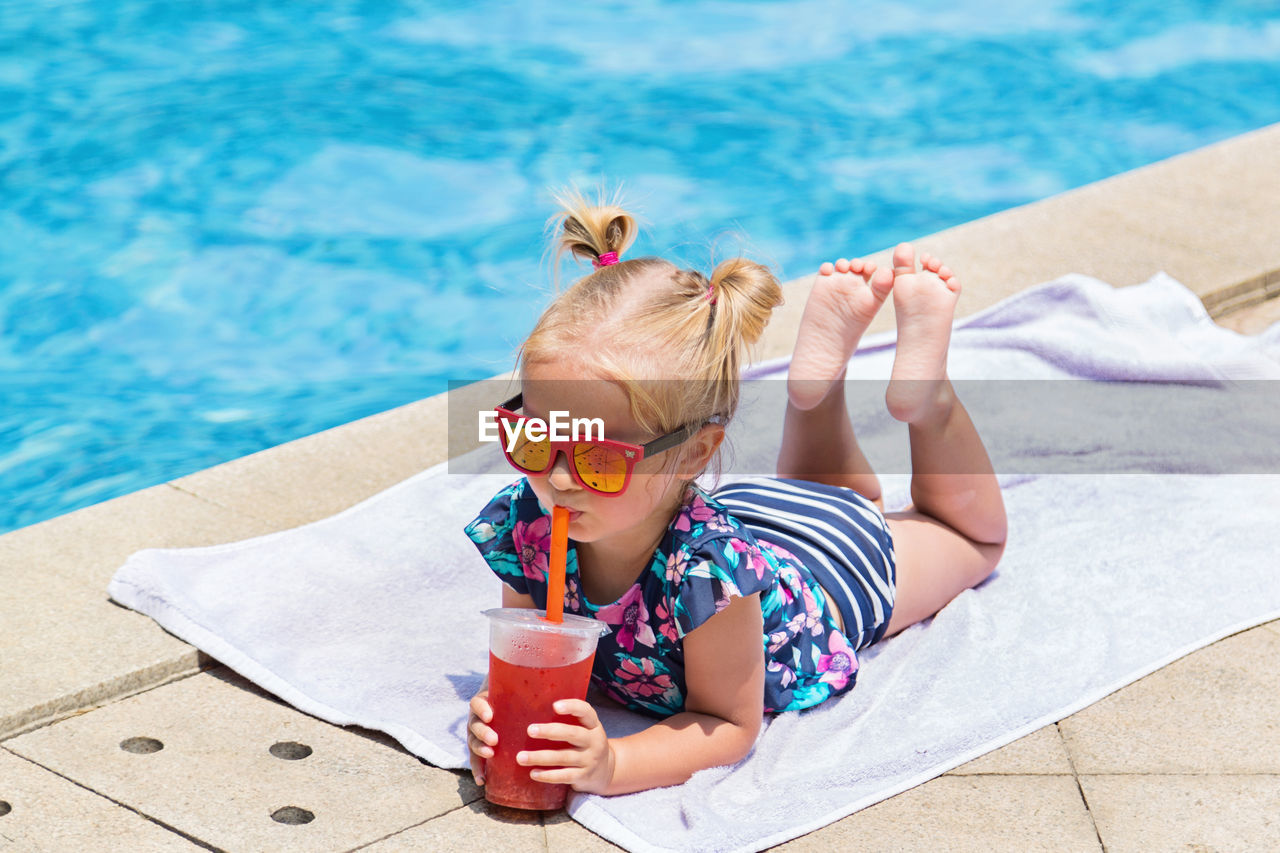 High angle view of cute boy drinking water in swimming pool