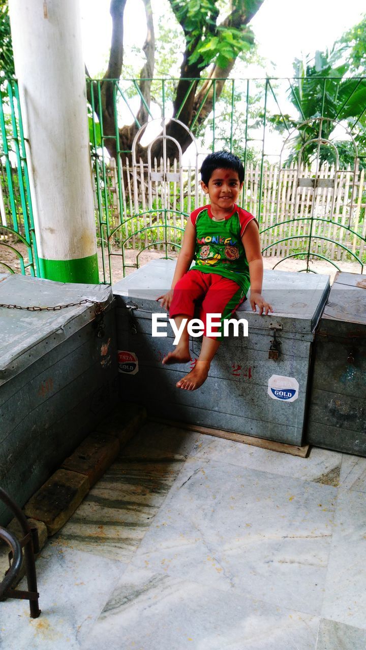 FULL LENGTH PORTRAIT OF BOY PLAYING ON SWING