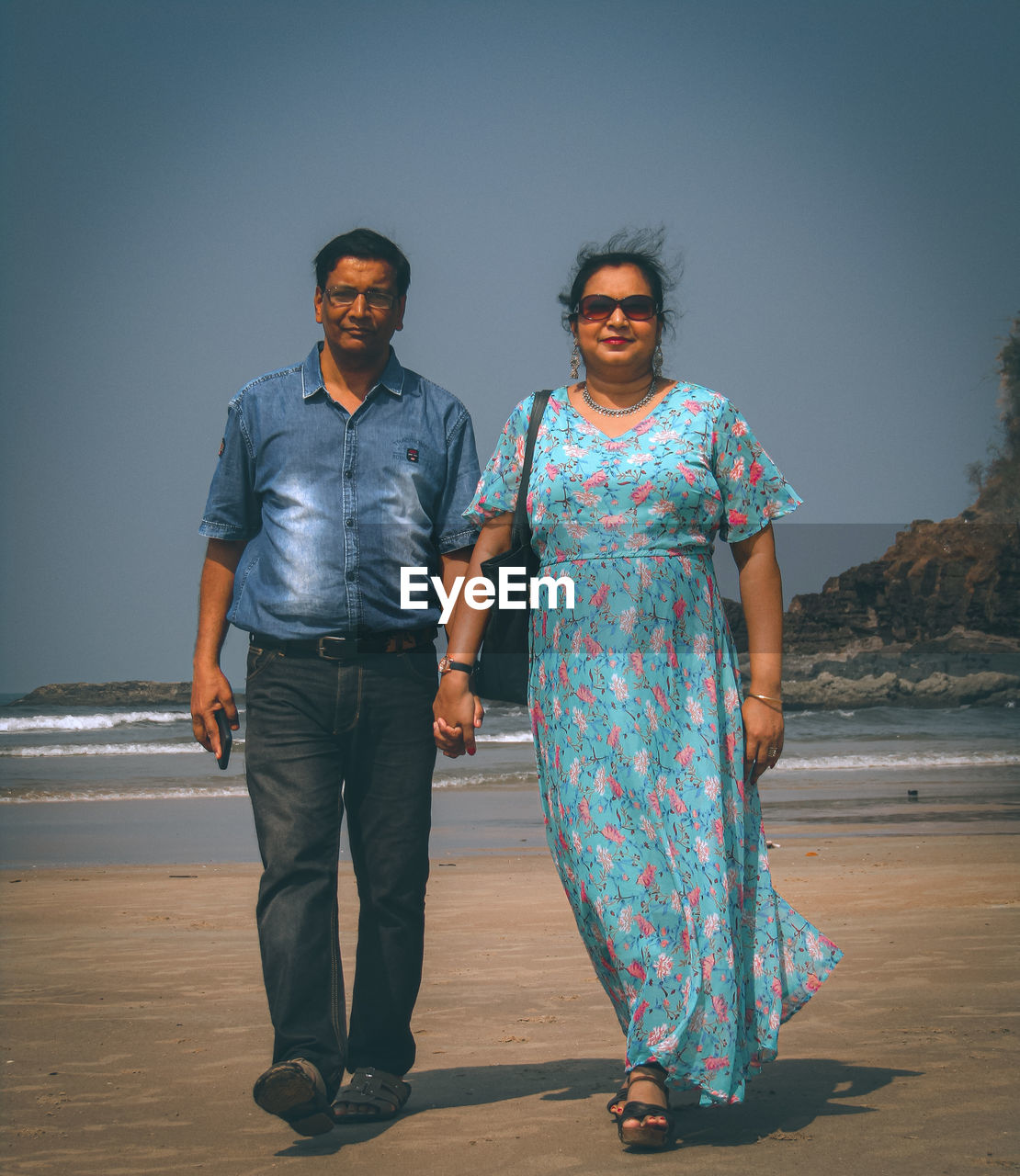 portrait of smiling couple standing against wall