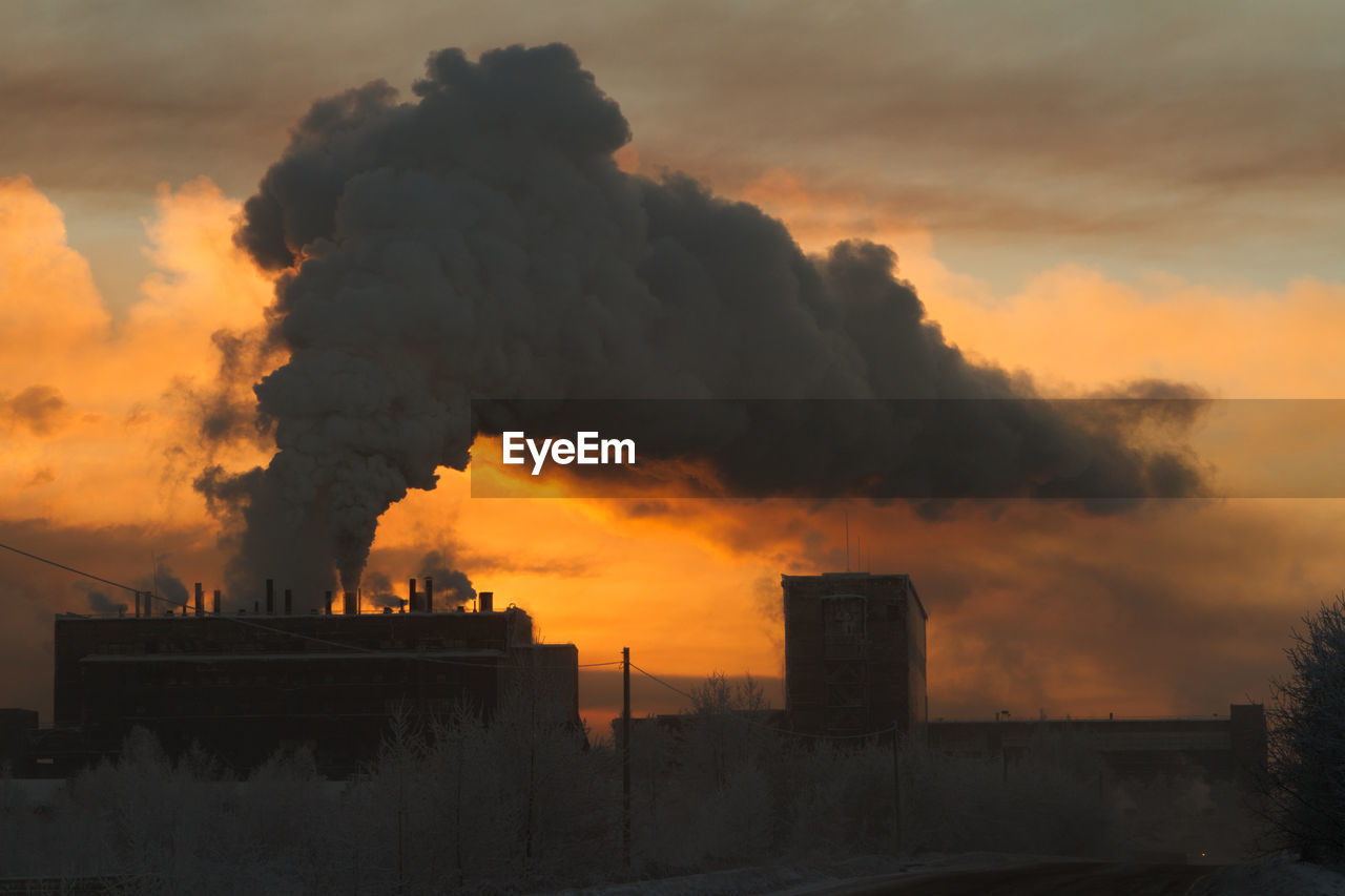 SMOKE EMITTING FROM CHIMNEY AGAINST SKY AT SUNSET