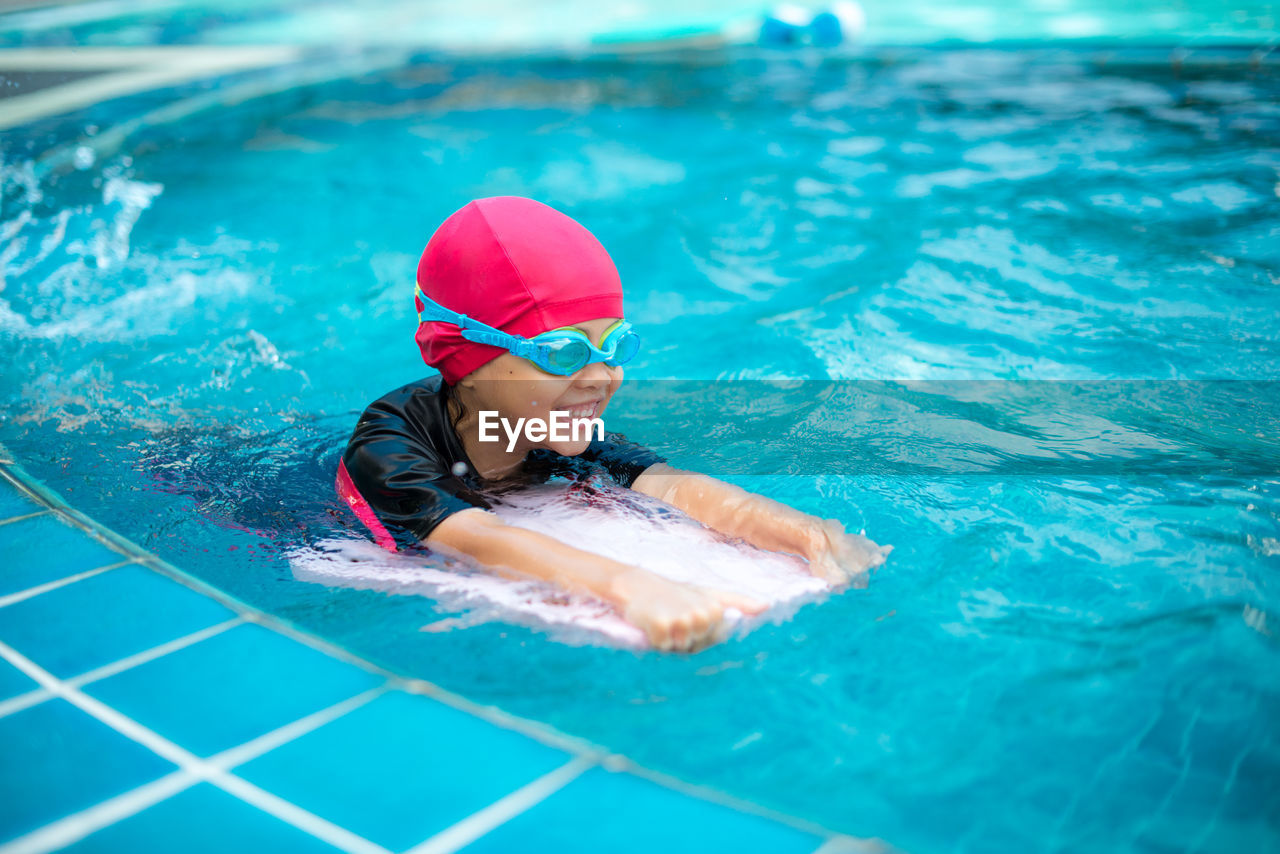 Smiling girl swimming in pool