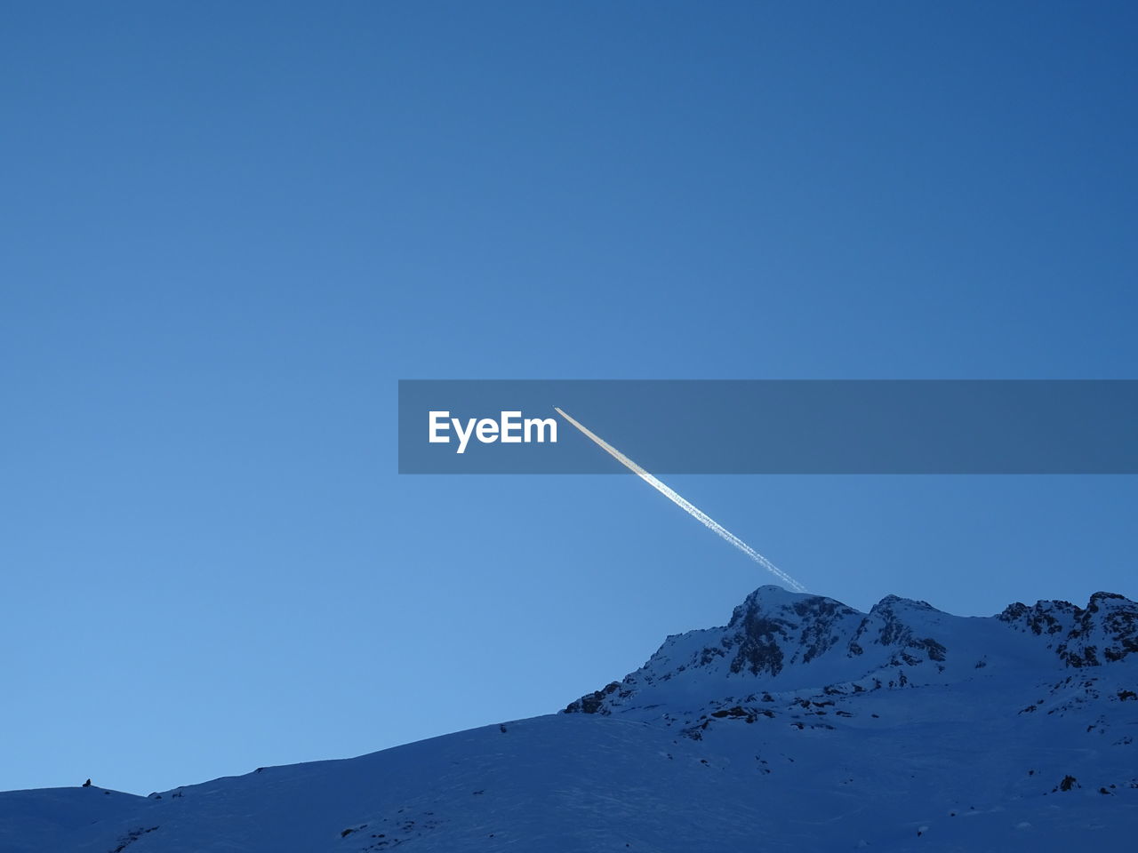 Scenic view of snowcapped mountains against clear blue sky