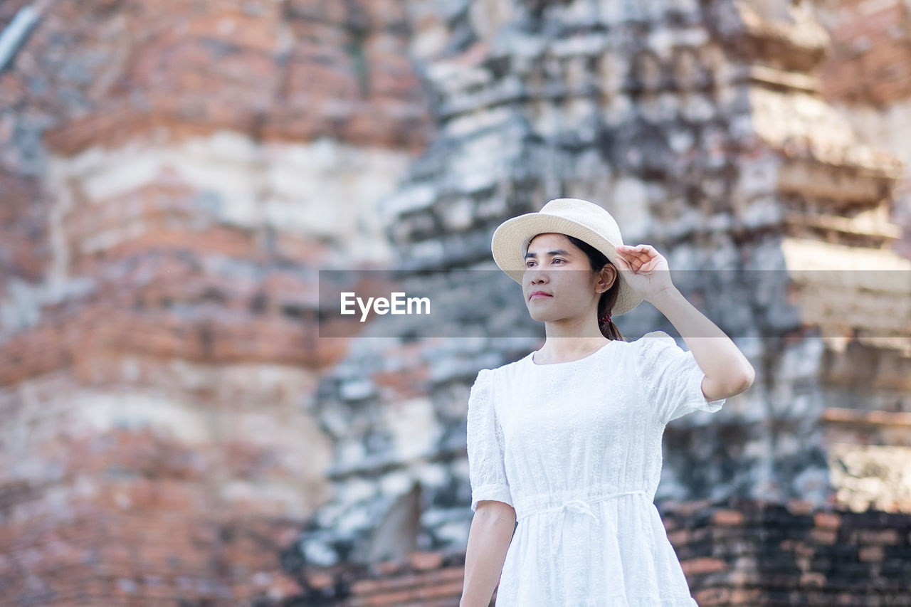 PORTRAIT OF YOUNG WOMAN WEARING HAT