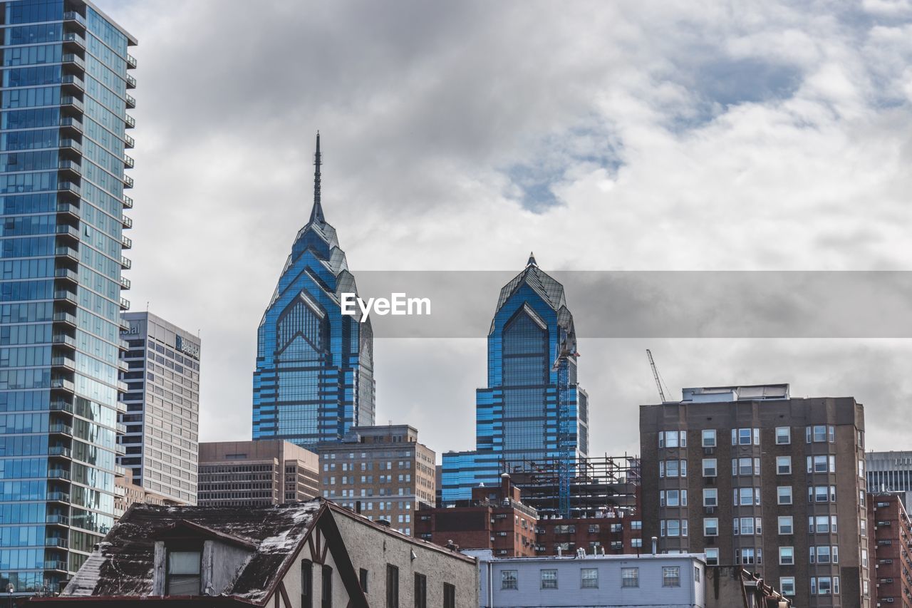 Low angle view of buildings against cloudy sky