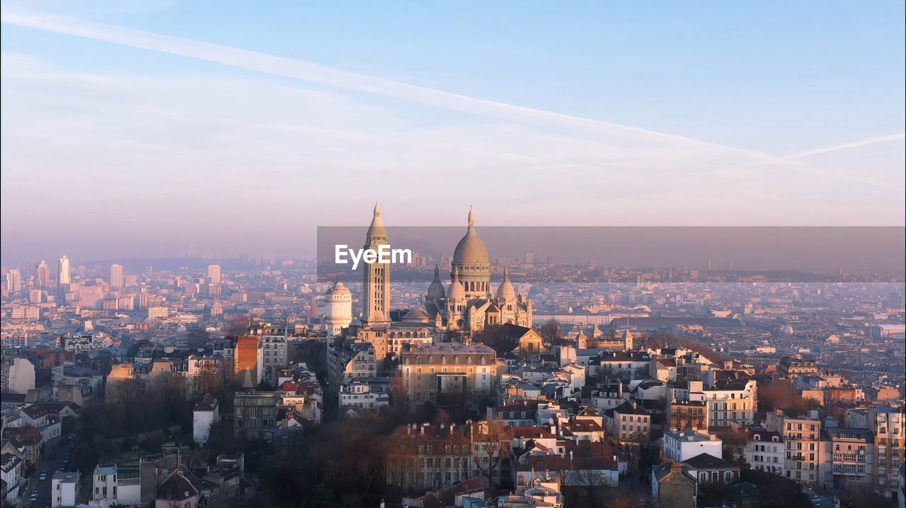 Aerial view of buildings in city against sky