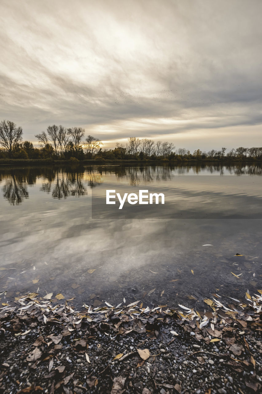 SCENIC VIEW OF LAKE AGAINST SKY DURING WINTER AT SUNSET