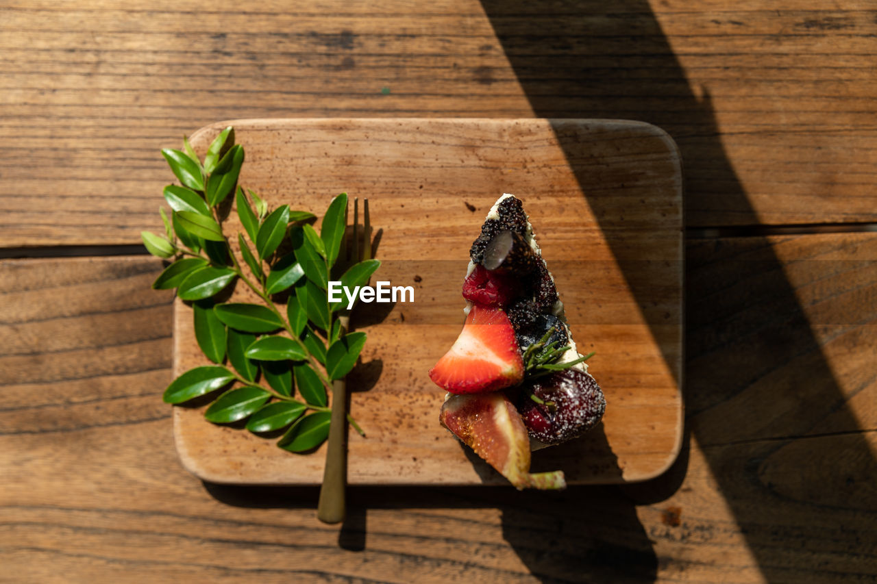 wood, food and drink, food, freshness, leaf, table, healthy eating, nature, high angle view, shadow, plant, sunlight, plant part, no people, wellbeing, indoors, produce, herb, still life, red, flower, green, fruit, vegetable, day, art