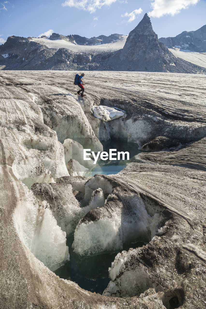 Man at meltwater pond, snowbird glacier, talkeetna mountains, alaska