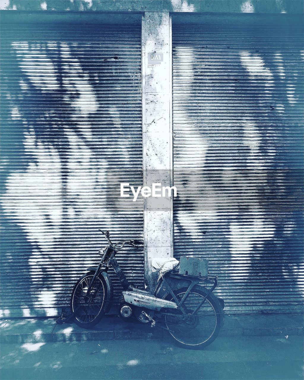 BICYCLE PARKED AGAINST BLURRED BACKGROUND