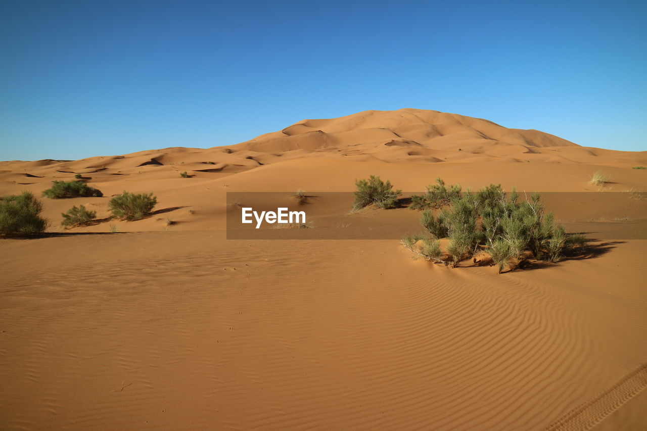 Scenic view of desert against cloudy sky