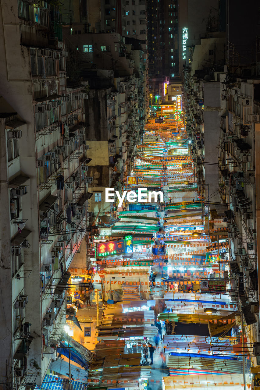 High angle view of illuminated night market amidst buildings in city