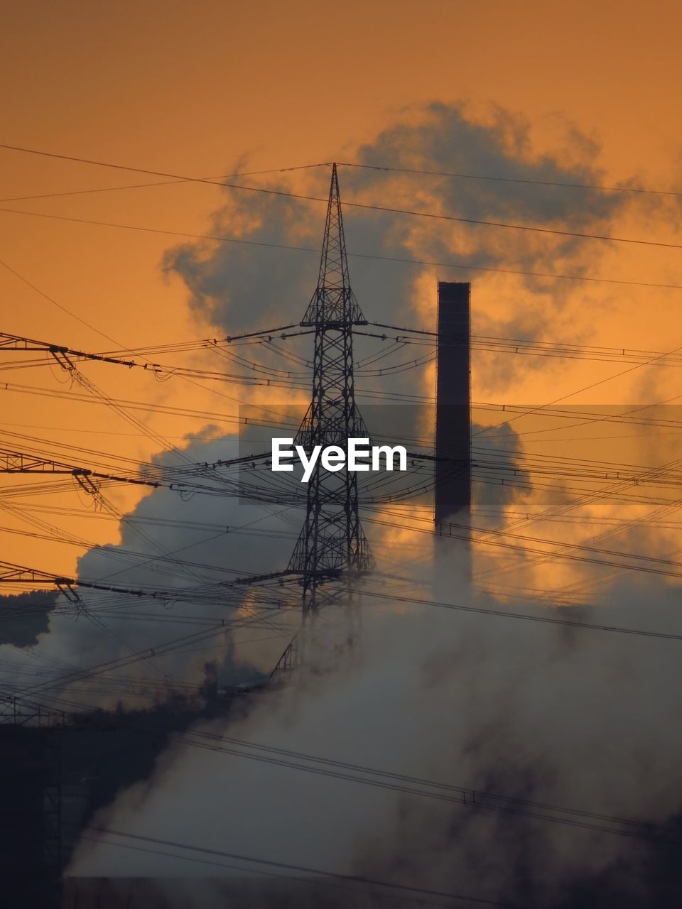 ELECTRICITY PYLONS AGAINST CLOUDY SKY