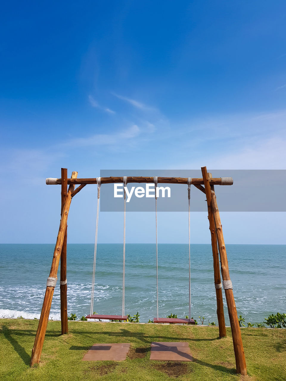 Wooden swing with tropical sea background. freedom and holidays concept.