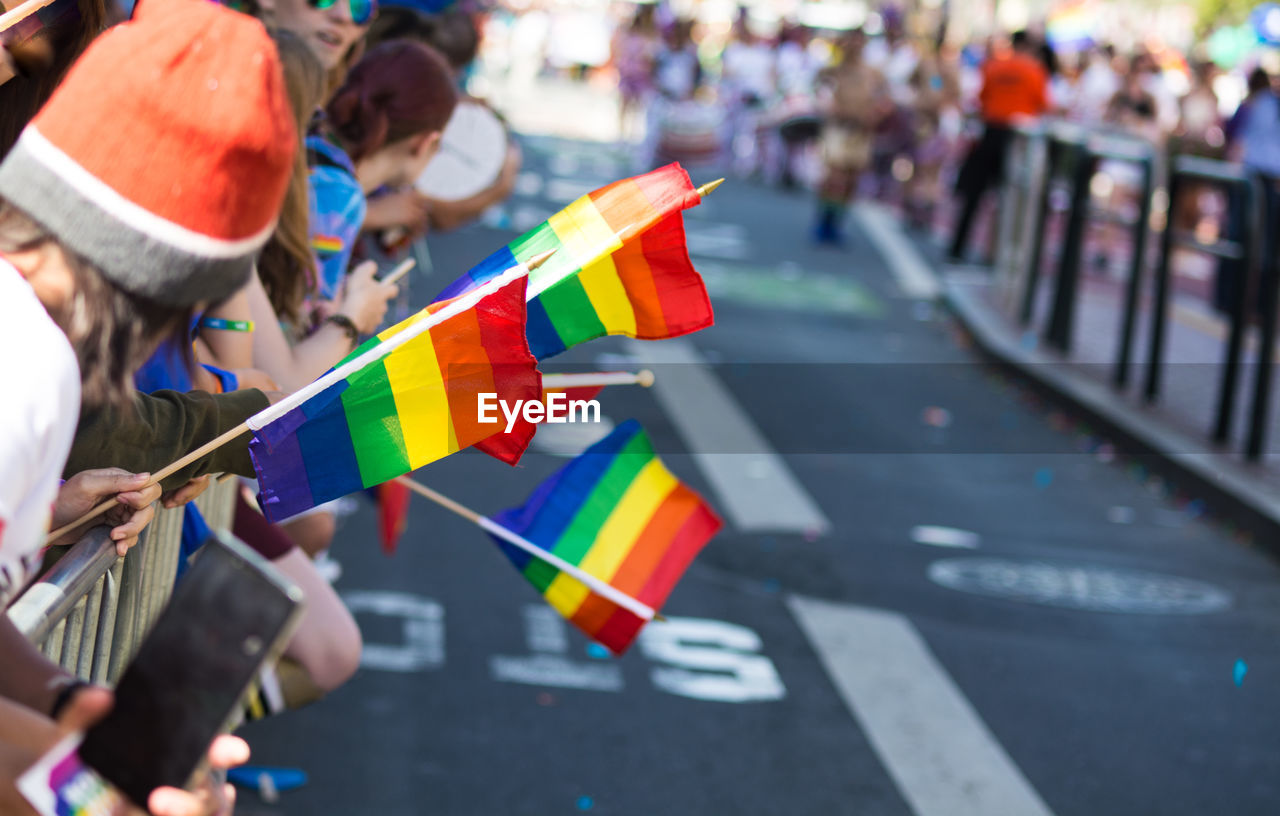 Group of people holding rainbow flags on street