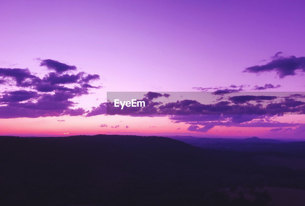 SCENIC VIEW OF SILHOUETTE MOUNTAIN AGAINST DRAMATIC SKY