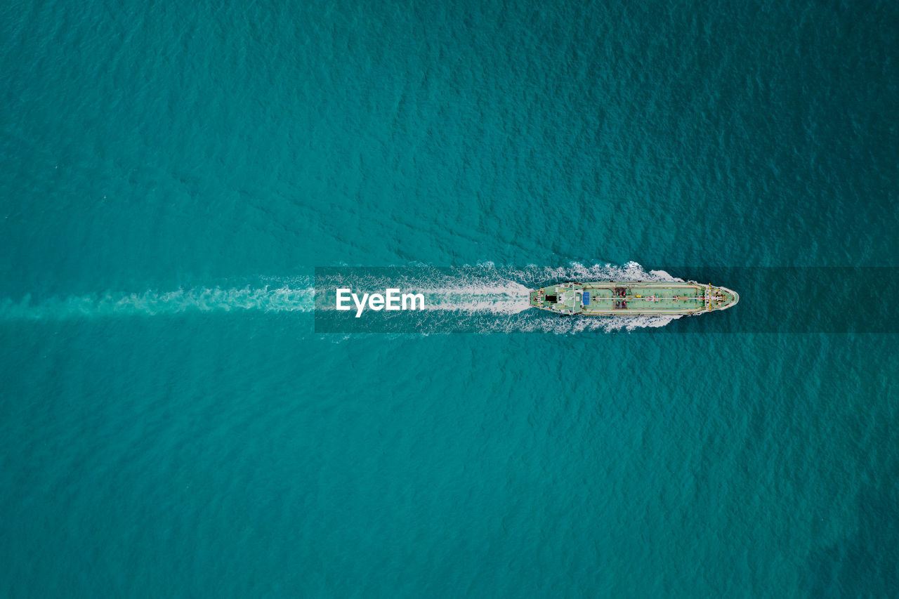 Aerial top view oil ship tanker full speed with beautiful wave and splash water in line 