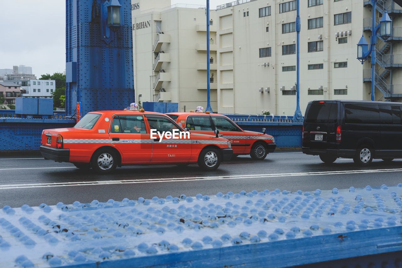 CARS ON STREET AGAINST BUILDINGS