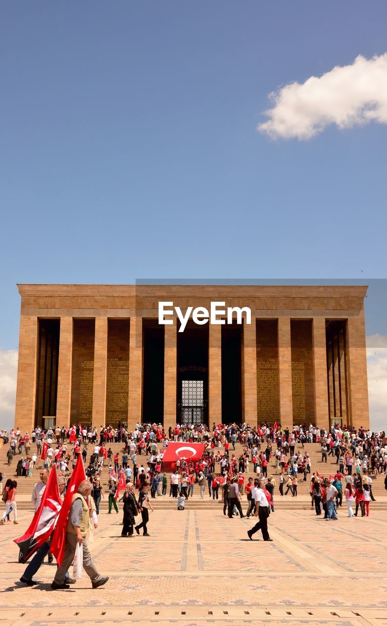 GROUP OF PEOPLE WALKING IN FRONT OF BUILDING