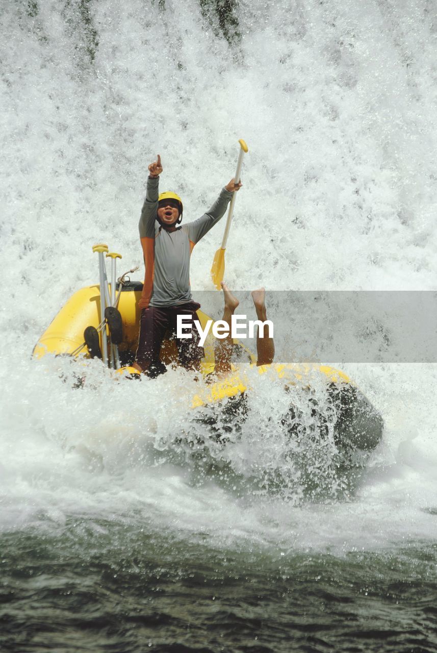 Cheerful man rafting in river