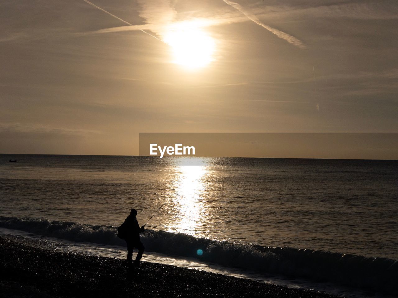 SILHOUETTE PERSON ON BEACH AGAINST SKY DURING SUNSET