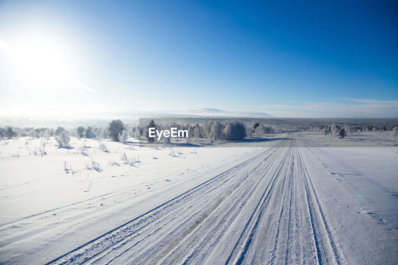 Snow covered field against sky