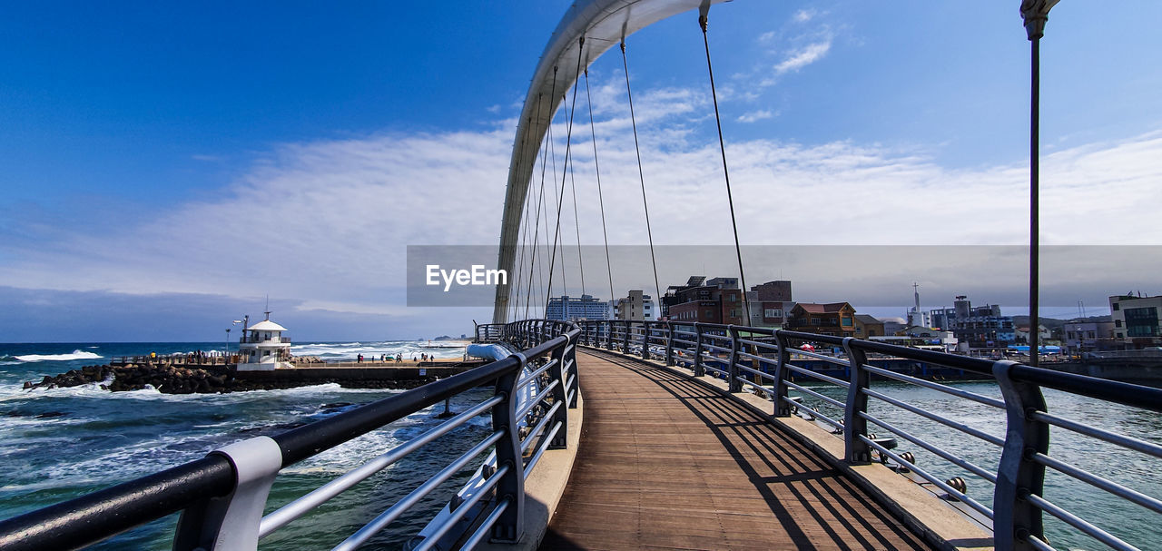 View of bridge over river against cloudy sky